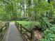 Picturesque walking path crossing a creek, surrounded by lush greenery and mature trees at 3600 Goldenrod Dr, Alpharetta, GA 30005
