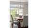 Bright dining room features modern chandelier and large window with views of the manicured yard at 3600 Goldenrod Dr, Alpharetta, GA 30005