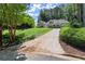 Charming home with a long driveway, lush green lawn, and mature landscaping at 3600 Goldenrod Dr, Alpharetta, GA 30005