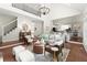 Spacious living room with hardwood floors, a fireplace, staircase, and open view into the kitchen at 3600 Goldenrod Dr, Alpharetta, GA 30005