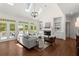 Bright living room featuring a fireplace, built-in shelves, hardwood floors, and access to an outdoor deck at 3600 Goldenrod Dr, Alpharetta, GA 30005