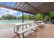 Community pool deck featuring picnic tables under a pergola and lounge chairs around the pool at 3600 Goldenrod Dr, Alpharetta, GA 30005