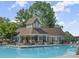 Community pool with an adjacent clubhouse featuring stone accents and a covered seating area at 3600 Goldenrod Dr, Alpharetta, GA 30005