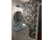 Stylish powder room featuring a glass bowl sink, decorative wallpaper, and updated lighting at 507 Spring Creek Ne Way, Marietta, GA 30068