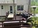 Spacious deck with outdoor seating, perfect for relaxation and entertaining, featuring a grill and lush surroundings at 507 Spring Creek Ne Way, Marietta, GA 30068