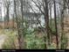 Two-story home with light blue shutters, surrounded by mature trees and lush greenery, offering a serene setting at 507 Spring Creek Ne Way, Marietta, GA 30068