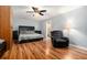 Comfortable main bedroom showcasing a plush recliner, ceiling fan, and hardwood floors at 507 Spring Creek Ne Way, Marietta, GA 30068