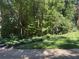 Well-manicured lawn and garden beds, nestled among mature trees, creating a private and peaceful outdoor space at 507 Spring Creek Ne Way, Marietta, GA 30068