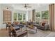 Bright living room featuring a ceiling fan, stylish furniture, and large windows with views of a wooded area at 1088 Battery Park Rd, Decatur, GA 30033