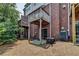 Exterior view of a brick home featuring a patio and upper level balcony at 3187 Mill Springs Cir, Buford, GA 30519