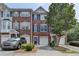 Brick townhome with blue shutters, attached garages, and mature landscaping provides great curb appeal at 3187 Mill Springs Cir, Buford, GA 30519