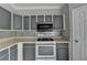 Kitchen showcasing the gray cabinets, white countertop, and stainless steel appliances at 3187 Mill Springs Cir, Buford, GA 30519