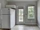 A bright kitchen features white appliances, tile flooring and access to a deck at 3187 Mill Springs Cir, Buford, GA 30519
