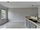 View of the kitchen with tile floor, gray lower cabinets and white upper cabinets at 3187 Mill Springs Cir, Buford, GA 30519