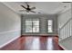Open-concept living room with hardwood floors, large windows, and neutral paint at 3187 Mill Springs Cir, Buford, GA 30519