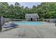 Community pool with lounge chairs surrounded by lush green trees at 3187 Mill Springs Cir, Buford, GA 30519