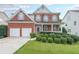 Traditional brick home showcasing a well-manicured front yard, two-car garage, and welcoming entrance at 5280 Lakerock Way, South Fulton, GA 30331