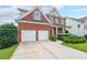 Brick home featuring an attached two car garage and landscaped yard with mature plantings at 5280 Lakerock Way, South Fulton, GA 30331