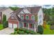 Lovely brick home with a cozy front porch, attached two-car garage, and lush, green landscaping at 5280 Lakerock Way, South Fulton, GA 30331