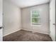 Empty carpeted bedroom with neutral walls, white trim, and a window with blinds at 6279 Marbut Farms Rd, Lithonia, GA 30058