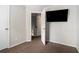 Carpeted bedroom featuring an open doorway, tv on the wall, and neutral walls at 6279 Marbut Farms Rd, Lithonia, GA 30058