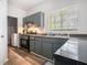 Galley-style kitchen with gray cabinets, granite countertops, and stainless steel appliances at 6279 Marbut Farms Rd, Lithonia, GA 30058