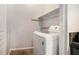 Enclosed laundry space with a white washing machine, storage shelving, and tile floors at 6279 Marbut Farms Rd, Lithonia, GA 30058