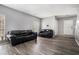 Spacious living room features two black couches, ample natural light, and stylish wood-look flooring at 6279 Marbut Farms Rd, Lithonia, GA 30058