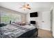 Comfortable main bedroom featuring a ceiling fan, large windows, TV, and carpet flooring at 6279 Marbut Farms Rd, Lithonia, GA 30058