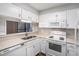 Bright kitchen featuring white cabinets, appliances, and a double stainless sink at 1800 Clairmont Lk # 412, Decatur, GA 30033