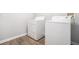 Laundry room with a white washer and dryer, light gray walls, and wood-look flooring at 1800 Clairmont Lk # 412, Decatur, GA 30033