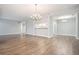 Open-concept living area with wood-look floors, neutral paint, and modern chandelier at 1800 Clairmont Lk # 412, Decatur, GA 30033