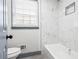 Updated bathroom with marble style tiled shower/tub combination at 4760 Silverdale Rd, College Park, GA 30349