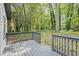 Wooden deck with gray rails overlooks a private, wooded backyard, perfect for relaxing or entertaining at 4760 Silverdale Rd, College Park, GA 30349