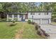 Well-maintained home featuring a white exterior, manicured lawn, and mature trees at 4760 Silverdale Rd, College Park, GA 30349