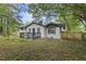 Charming home with black trim, black deck, brick and siding, nestled in a lush, wooded setting at 4760 Silverdale Rd, College Park, GA 30349