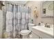 Bathroom showcasing a shower with patterned curtain, toilet, vanity and a mounted mirror at 992 Brian Ln, Forest Park, GA 30297