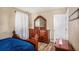 This bedroom features a wood dresser with a large mirror, hardwood floors and an elegant bed at 992 Brian Ln, Forest Park, GA 30297