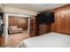 Spacious bedroom with wood paneling, TV, and seating area at 992 Brian Ln, Forest Park, GA 30297