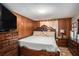 Bedroom featuring wood paneling, a large bed, and ample dresser storage at 992 Brian Ln, Forest Park, GA 30297
