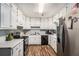 Bright kitchen with white cabinetry, stainless steel appliances, and wood-look flooring at 992 Brian Ln, Forest Park, GA 30297