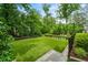 View of the lush backyard with privacy landscaping, a basketball court and grass at 4048 Navajo Trl, Brookhaven, GA 30319