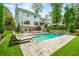An inviting backyard featuring a pool, waterfall feature, lounge chairs, and a comfortable seating area with a fire pit at 4048 Navajo Trl, Brookhaven, GA 30319