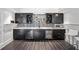 Stylish bar area with sleek black cabinetry, wine fridge, mosaic backsplash, and marble countertops at 4048 Navajo Trl, Brookhaven, GA 30319