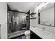 Updated bathroom with a frameless shower, black accents, and marbled countertops at 4048 Navajo Trl, Brookhaven, GA 30319