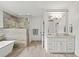 Bright bathroom featuring double sinks, soaking tub, and glass shower at 4048 Navajo Trl, Brookhaven, GA 30319