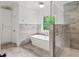 Bright bathroom featuring soaking tub, glass shower, and built-in storage at 4048 Navajo Trl, Brookhaven, GA 30319