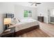 Bright bedroom with a dark wood bed frame, wood floors, and large window at 4048 Navajo Trl, Brookhaven, GA 30319