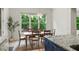 Bright dining room featuring a wooden table, chairs, decorative rug, and a window view to a wooded setting at 4048 Navajo Trl, Brookhaven, GA 30319