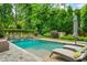 Beautiful pool area with lounge chairs, a waterfall feature, and a comfortable seating area with a fire pit at 4048 Navajo Trl, Brookhaven, GA 30319